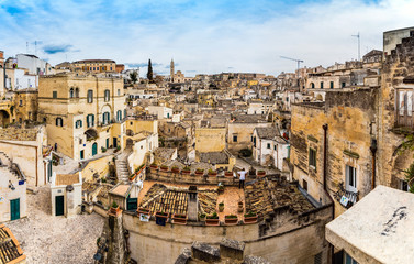 Fototapeta premium Long panoramic views of the rocky old town of Matera with its stone roofs.
