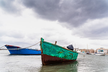 Fototapeta na wymiar Small boat moored to Bari port, Italy, during a storm at sea.