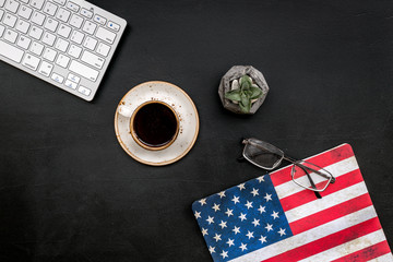 Independence day of USA with flag, keyboard, glasses, coffee, plant on black background top view