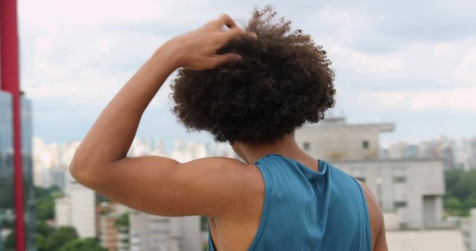 Young black man overlooking city view on top of building, casual and sport