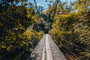 Old wooden bridge with metal railings in Thailand