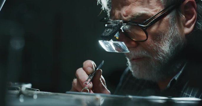 Slow motion of experienced goldsmith sorting high quality stones, selecting them to make precious jewels with diamonds in workshop.Shot in 8K.Concept of jewelry,luxury,goldsmith, diamonds, brilliance.