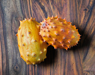 Two kiwano fruits on a wooden background