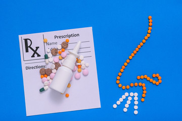 Nose of pills, spray and lots of prescription pills on blue background. The concept of treatment of diseases of the nose and allergies. Flat lay.