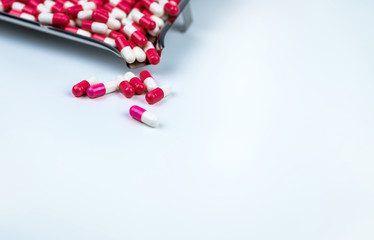 Pink-white and red-white capsule on white table and blurred stainless steel drug tray. Love pills...