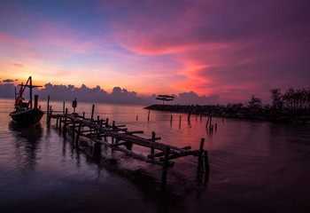 The background of the morning sunrise scenery by the sea, the fishing boats parked in the blurred beauty of the sea breeze that passes through, is the beauty of nature during traveling.