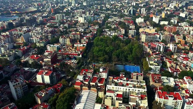 DRONE FLIGHT OVER PARK IN MEXICO CITY RESIDENTIAL AREA. KIDS PLAYGROUND COLORFUL, BLUE BASKETBALL COURT, AND CITY STABLISH