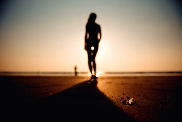 Fototapeta na wymiar Woman on beach in sunset