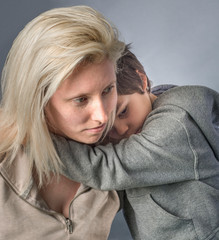 Little boy in gray sweatshirt shares moment of love  with mother
