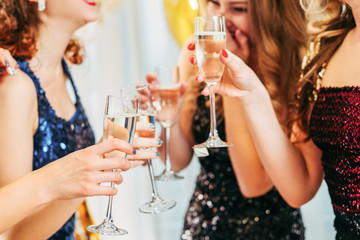 Fancy party. Special event. Cropped closeup of girls holding glasses with champagne, chatting, laughing, having fun.