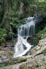 Fototapeta na wymiar Huay Kaew Waterfall in tropical rain-forest, stones. Summer, travel, jungle concept. Copy space, vertical format