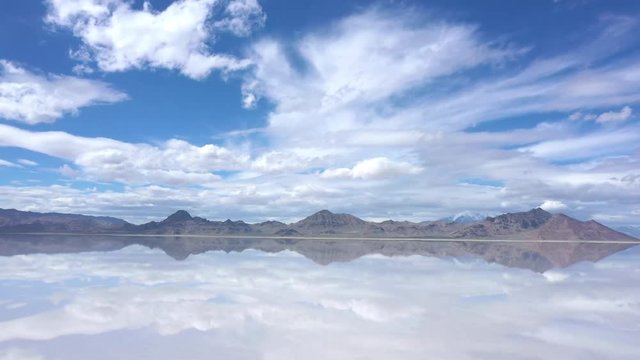 View of clouds reflecting in water over the Bonneville Salt Flats as water covers the landscape in Utah during Spring.