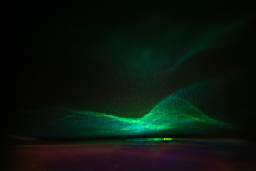 Blurred green lights on dark background. Defocused lens flare glow. Optical effect
