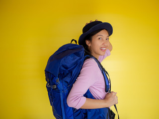 Beautiful traveler asian woman with backpack isolated on yellow background , summer travel concept. 
