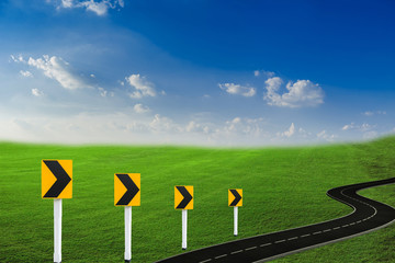 Grass fields, fine grass, bright green, sky and clouds and black roads, plants in nature Nature background Can be used as a background image or add text