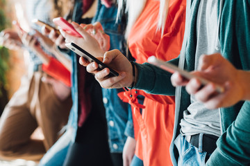 Millennial generation. Colorful cropped closeup of young people holding smartphones. Modern devices. Technological progress. - obrazy, fototapety, plakaty