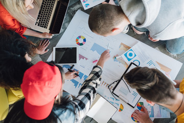 Working together toward common goal. Successful business team analyzing diagrams. Strategy to...