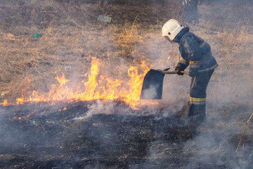 Raging forest spring fires. Burning dry grass, reed along lake. Grass is burning in meadow. Ecological catastrophy. Fire and smoke destroy all life. Firefighters extinguish Big fire. Lot of smok © Torkhov