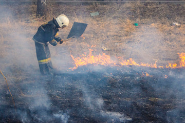Raging forest spring fires. Burning dry grass, reed along lake. Grass is burning in meadow. Ecological catastrophy. Fire and smoke destroy all life. Firefighters extinguish Big fire. Lot of smok © Torkhov