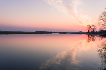 Peaceful landscape with the colorful sunrise over the river landscape of the swamp water at dawn