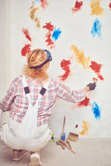 Working woman plastering / painting walls inside the house.