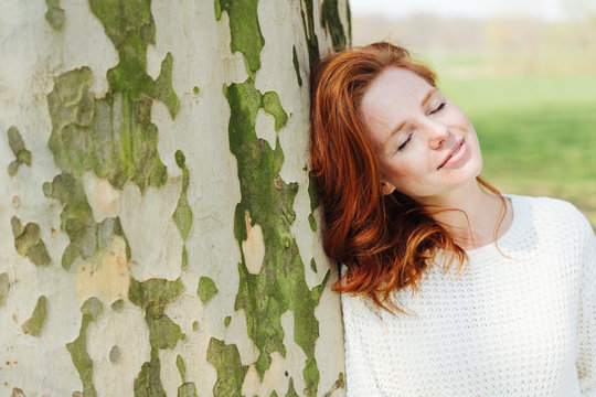 Peaceful young redhead woman enjoying nature