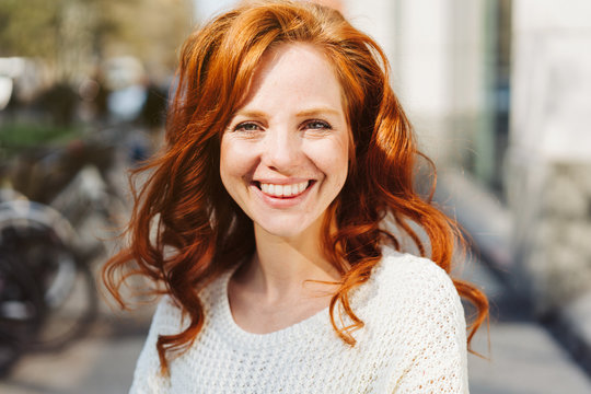 Friendly young redhead woman with vivacious smile