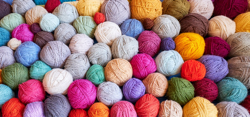 Colorful background made of many wool yarn balls.