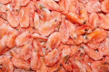 Raw shrimp background. Pile of frozen shrimps on white background.Close-up of frozen shrimps. Shrimp and ice, top view.