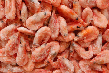 Raw shrimp background. Pile of frozen shrimps on white background.Close-up of frozen shrimps. Shrimp and ice, top view.