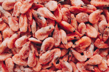 Raw shrimp background. Pile of frozen shrimps on white background.Close-up of frozen shrimps. Shrimp and ice, top view.