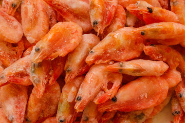 Raw shrimp background. Pile of frozen shrimps on white background.Close-up of frozen shrimps. Shrimp and ice, top view.