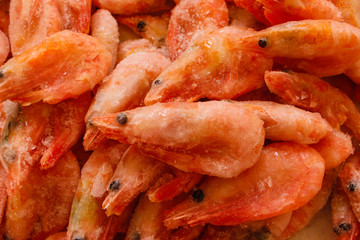 Raw shrimp background. Pile of frozen shrimps on white background.Close-up of frozen shrimps. Shrimp and ice, top view.