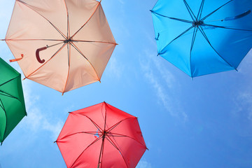 Vibrant colorful opened umbrellas in the sky background.