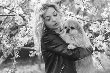 Portrait of nice woman and her dog in garden, pets concept 