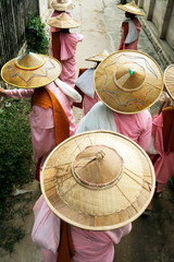 Naklejka premium Novice nun walking with bamboo hat in the historical park of Bagan,Myanmar