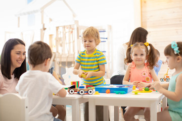 Group of kids playing together in the classroom in kindergarten or preschool