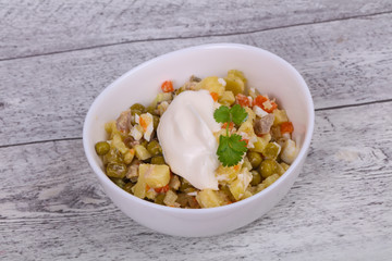 Traditional Russian salad with chicken in the white bowl