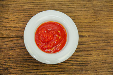 Mustard in a white Cup on a cutting Board