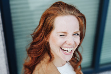 Cute playful young woman winking at camera