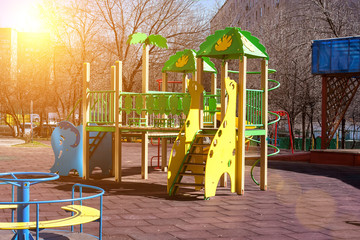 Children's playground in the courtyard of a multistory building. colorful swings and slides are installed.