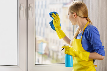 Woman cleaning window at home