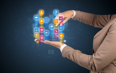 Female elegant hand holding tablet with colourful application icons