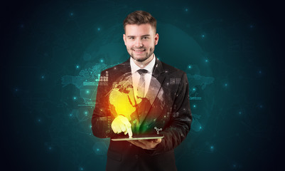 Fototapeta premium Spectacled businessman with global hologram concept and tablet on his hand 