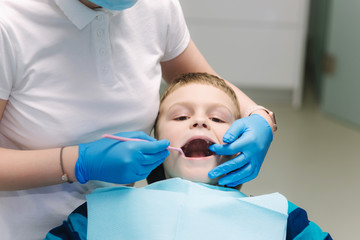 Young boy sitting on the dental chair at the office. Children's dentist examination baby teeth