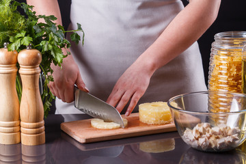 young woman in a gray apron cuts marinated pineapple