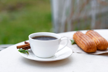 Fragrant coffee with eclairs in the summer cafe.