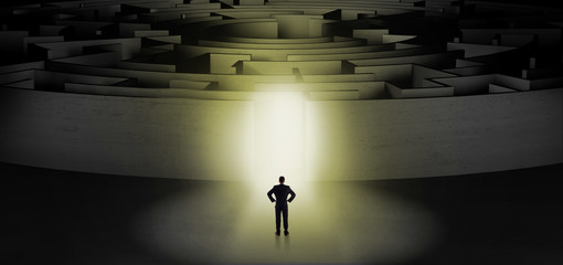 Businessman getting ready to enter a concentric labyrinth with lighted entrance concept
