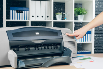 Woman making photocopy using copier in office