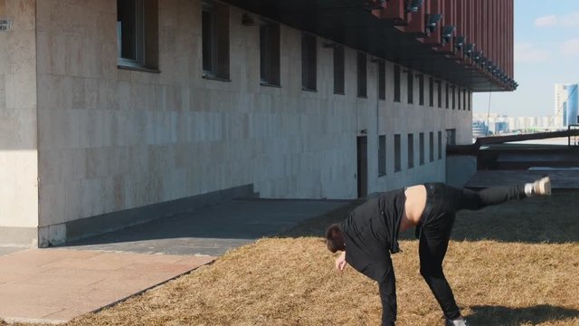 A man performing acrobatic tricks and flips on the grass